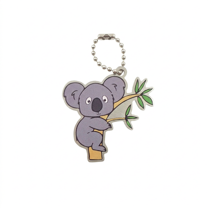 Sydney the Koala travel tag hugging a eucalyptus branch with compact silver chain on white