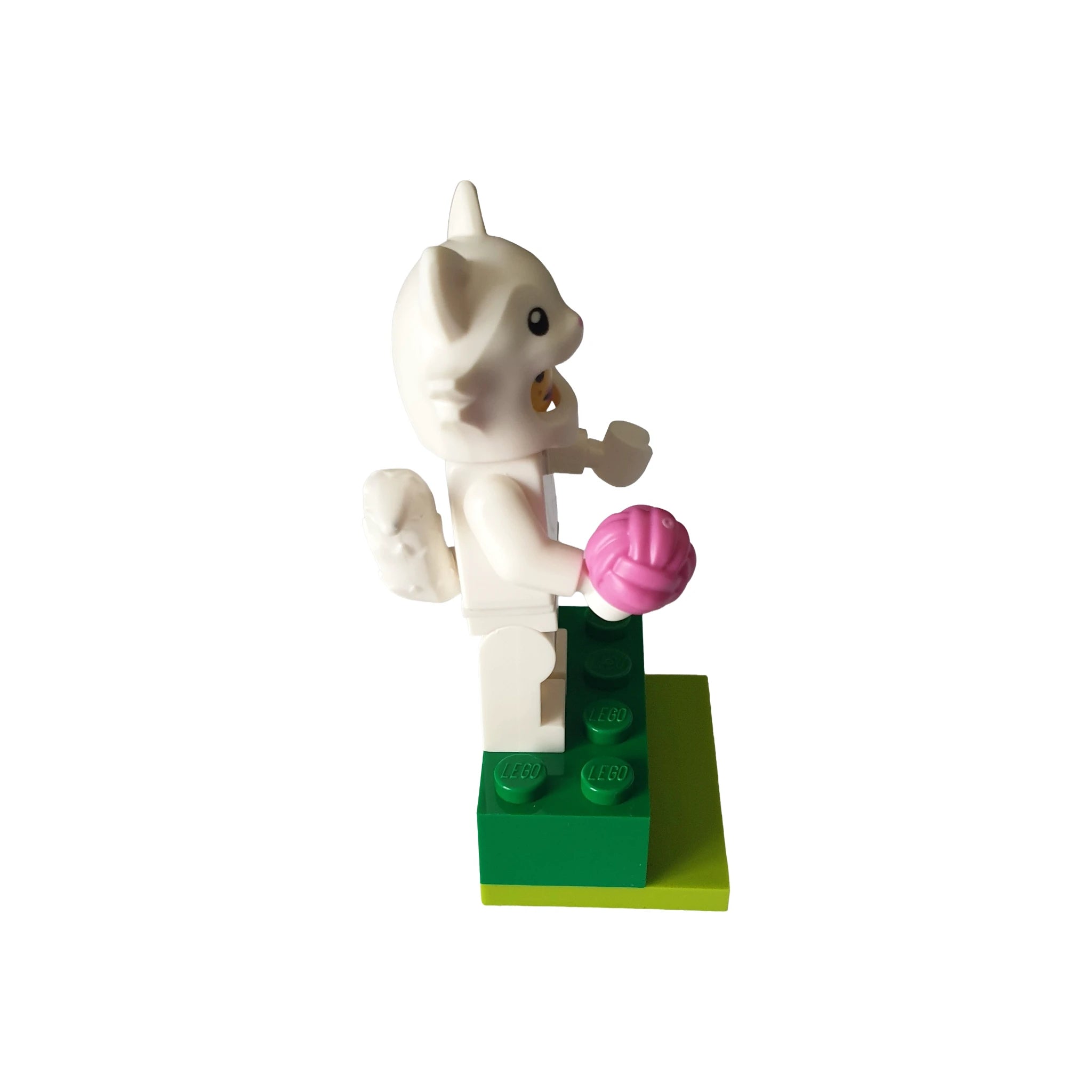 White cat costume LEGO minifigure holding pink accessory on green base, collectible geocaching toy