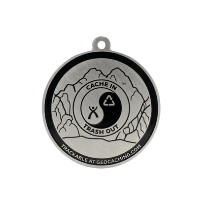 Reverse of CITO trackable tag with mountain engraving and tracking code hidden on a white background