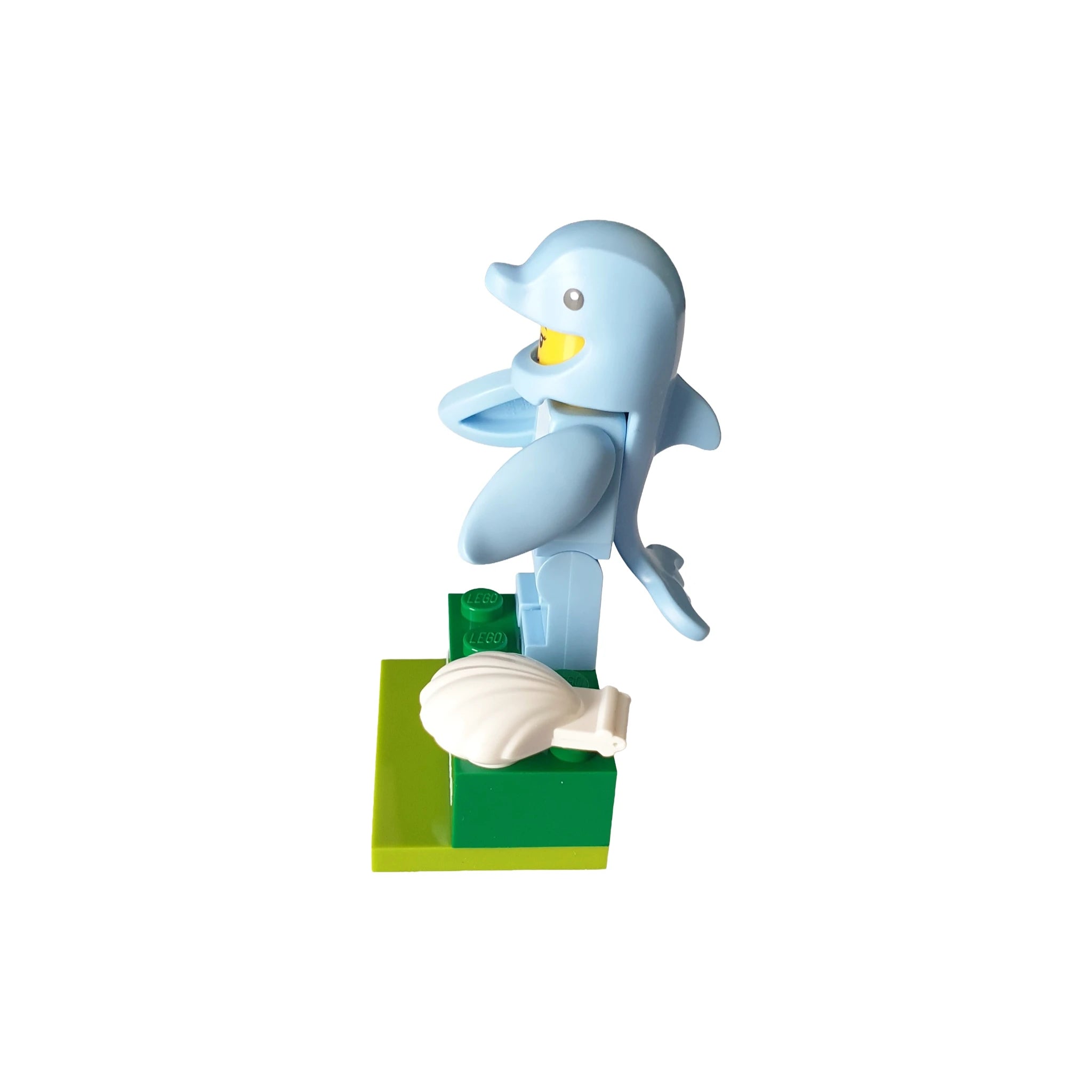 Blue dolphin-themed LEGO minifigure on green baseplate with white seashell accessory