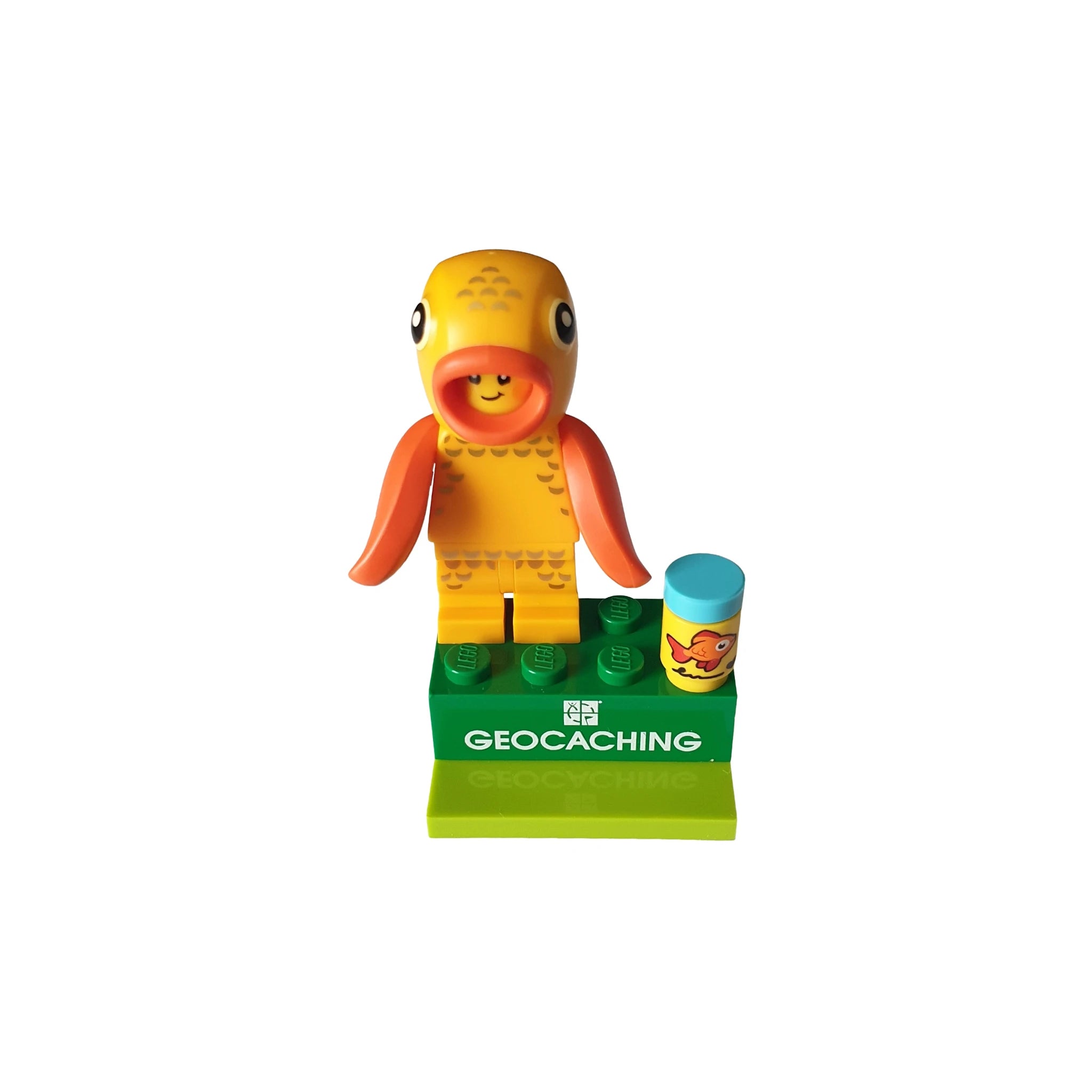 Geocaching toy figure in orange fish costume on green base with fish-themed accessory