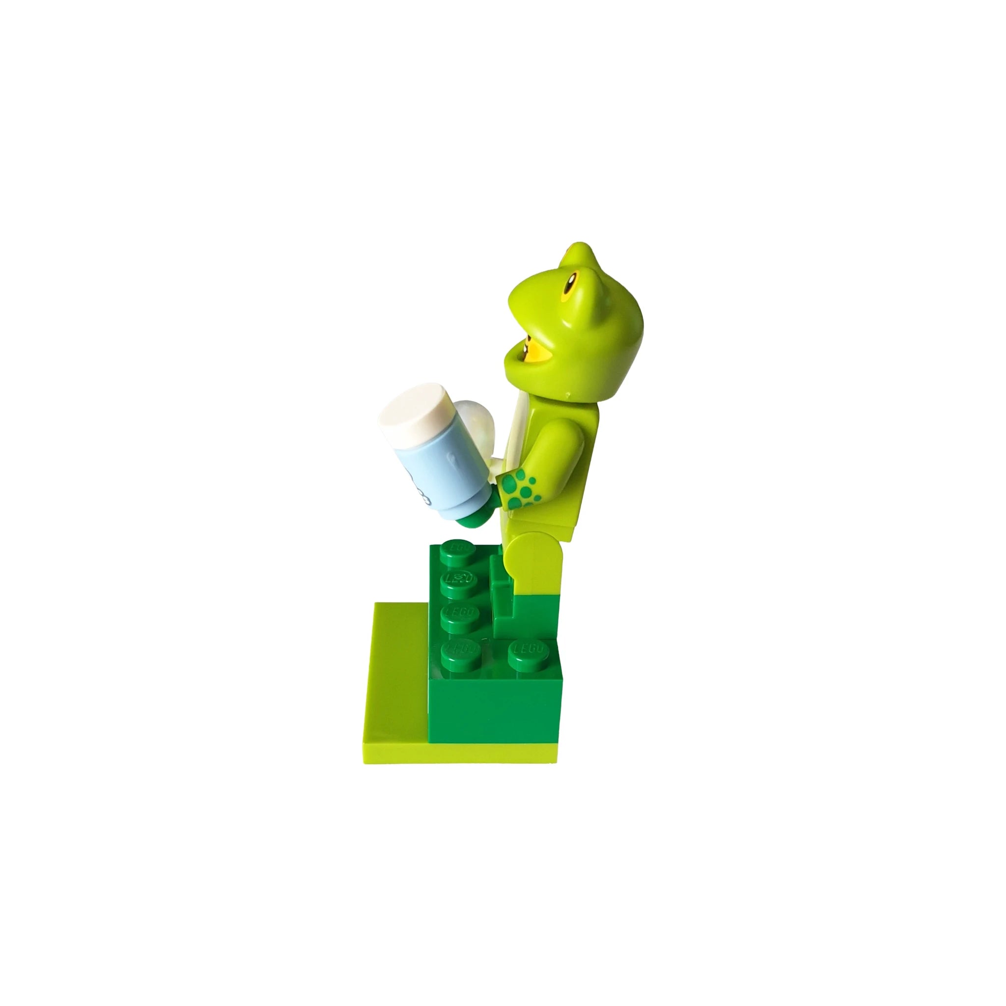 Green frog-themed toy figure holding container, geocaching container on LEGO base