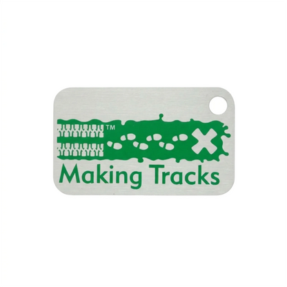 Green Making Tracks metal trackable tag with tyre tracks, footprints and X design on a white background